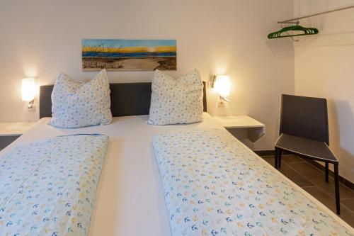 a bedroom with a white bed with blue pillows at Oase am Siel 4 in Dornumersiel