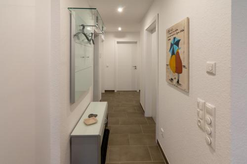 a hallway with a bathroom with a sink and a mirror at Oase am Siel 4 in Dornumersiel