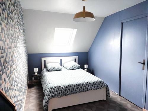 a bedroom with a bed and a blue wall at Charmante maison proche plage et port in Camaret-sur-Mer