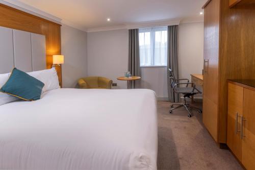 a hotel room with a bed and a desk at Crowne Plaza East Midlands Airport by IHG in Derby