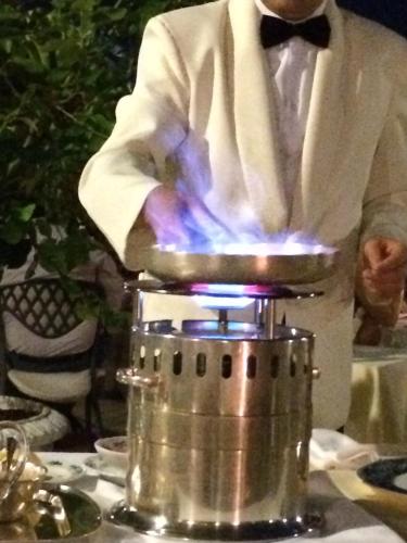 a man in a suit standing next to a blender at Hotel Villa Del Sogno in Gardone Riviera