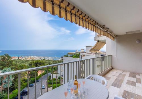 un balcon avec une table et une vue sur l'océan dans l'établissement Le Mirador, vue mer, piscine, terrasse, à Menton