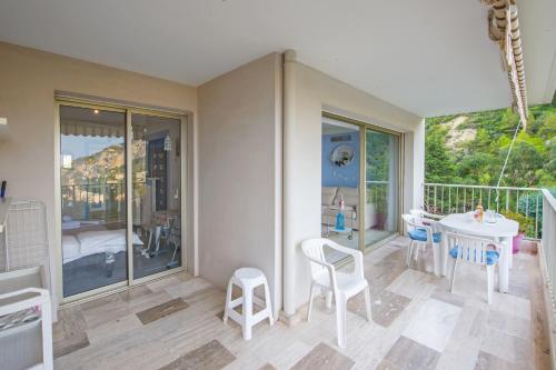 une chambre avec un balcon avec une table et des chaises dans l'établissement Le Mirador, vue mer, piscine, terrasse, à Menton