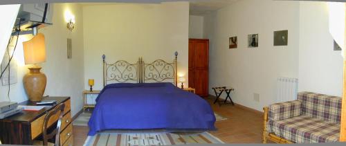 a bedroom with a blue bed and a couch at Case Zuccaro in Trecastagni