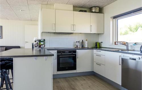 eine Küche mit weißen Schränken und einer Spüle und einem Herd in der Unterkunft Lovely Home In Allinge With Wifi in Allinge