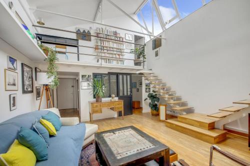 - un salon avec un canapé bleu et des escaliers dans l'établissement Paris Super Loft Overtop, à Paris