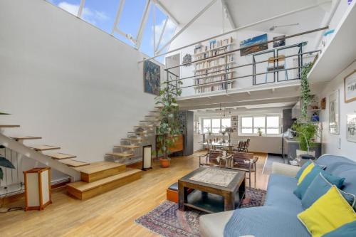 - un salon avec un canapé bleu et des escaliers dans l'établissement Paris Super Loft Overtop, à Paris