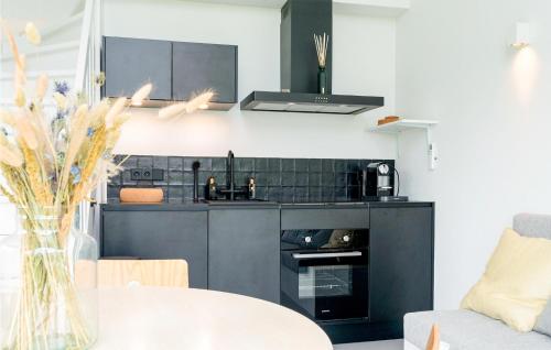 a small kitchen with black cabinets and a table at Pet Friendly Home In Vlissingen in Vlissingen