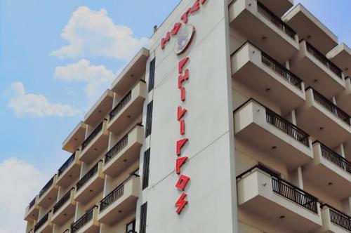 un hôtel avec un panneau sur le côté d'un bâtiment dans l'établissement Hotel Philippos, à Vólos