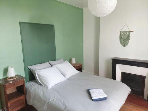 - une chambre avec un lit blanc et une cheminée dans l'établissement Grand Gîte Les Chemisières, à Argenton-sur-Creuse