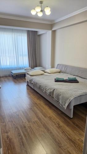 a bedroom with a large bed and a wooden floor at AIRPORT-TAXI-PARKING-Card in Chişinău