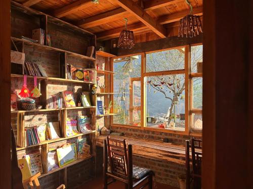 a room with two chairs and a book shelf with books at La Beauté Sa Pa in Sa Pa