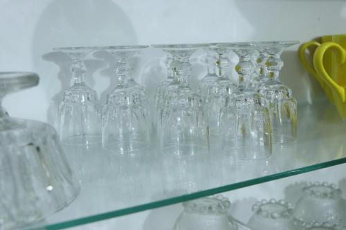 a group of glass vases on a glass shelf at Sheru Guest in Matara