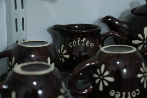 three black coffee mugs with flowers painted on them at Sheru Guest in Matara