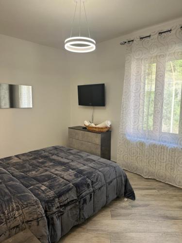 a bedroom with a bed and a flat screen tv at Casa Gaudi in Piancastagnaio