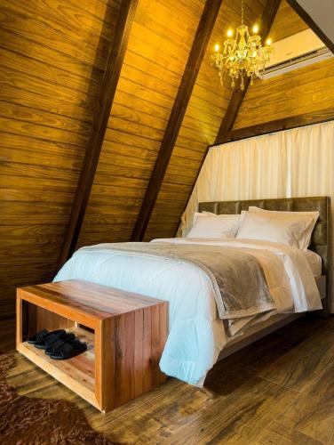 a bedroom with a bed and a chandelier at Pousada Duas Marias in Nova Veneza