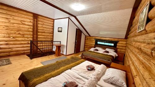 a room with two beds in a log cabin at Chalet Vedmezhe in Polyana