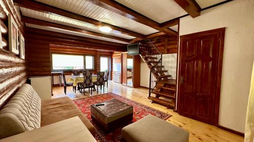 a living room with a couch and a staircase at Chalet Vedmezhe in Polyana