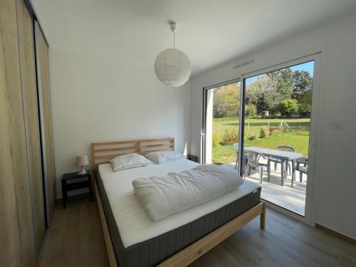 une chambre avec un lit et un balcon avec une table dans l'établissement Les Aigrettes, à Sarzeau