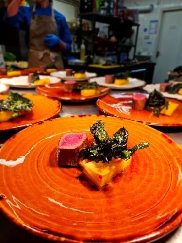 a table with orange plates of food on it at The Shears Inn in Marlborough