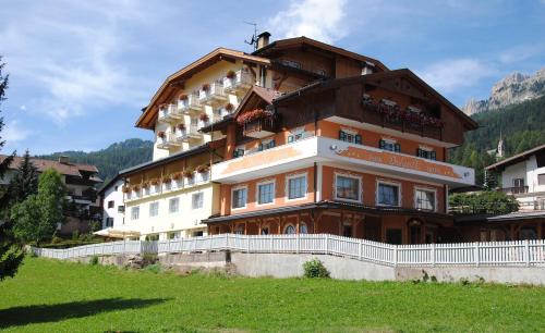 a large building on top of a green field at Dolasilla Park Hotel in Vigo di Fassa