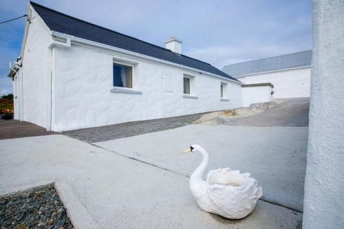 a white swan sitting on the side of a building at 17 Mountaindale in Tullaghan