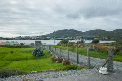 a fence with flowers next to a body of water at 17 Mountaindale in Tullaghan