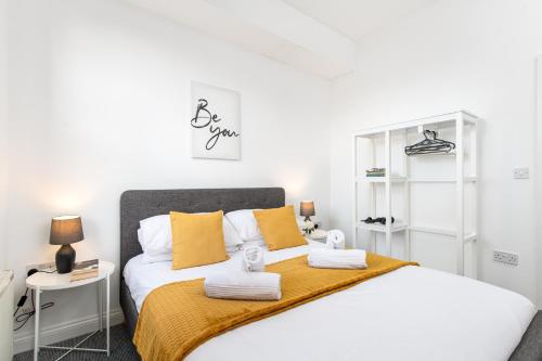 a bedroom with a large bed with yellow pillows at Large 1 bed Flat-Long Stays-By MatchstickStays in Bristol