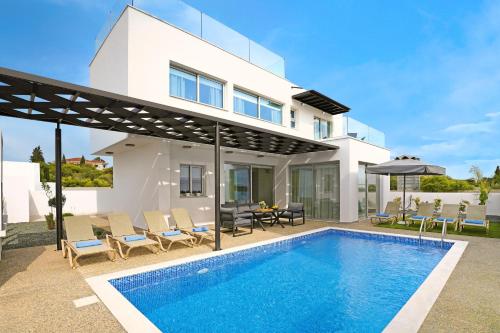 a villa with a swimming pool and a house at Villa Napa Blu in Ayia Napa
