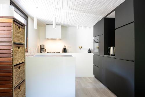 a kitchen with a white counter and black cabinets at Superb Chalet Monterosa in Anzino