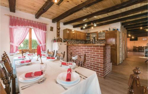une salle à manger avec une table et une cuisine dans l'établissement Four-Bedroom Holiday Home In Velika Buna, à Velika Buna