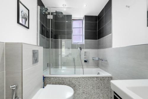 a bathroom with a tub and a toilet and a sink at The Bronwen in London