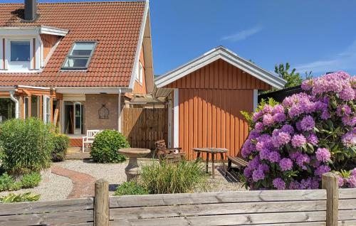 a house with a wooden fence and purple flowers at 3 Bedroom Beautiful Home In Höganäs in Höganäs