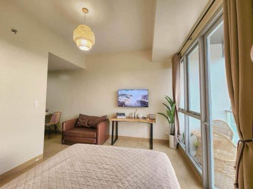 a bedroom with a bed and a table and a chair at The Palladium Iloilo City in Iloilo City