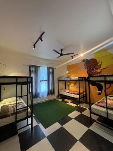 a room with three bunk beds and a checkered floor at Himtrek Stay Kasol in Kasol