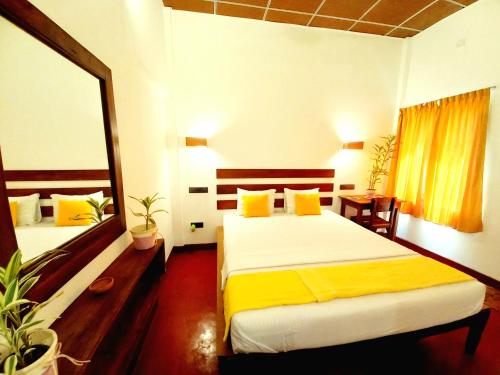 a hotel room with two beds and a mirror at Coco Garden Villas 4 in Hikkaduwa