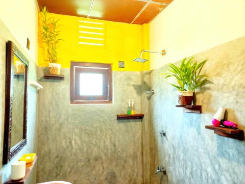 a bathroom with a sink and a shower with a window at Coco Garden Villas 4 in Hikkaduwa