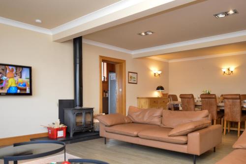 a living room with a couch and a fireplace at Taigh na Mara in Kames