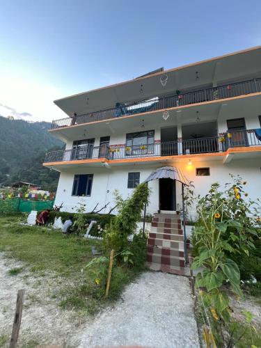 a white building with a staircase in front of it at Himtrek Stay Kasol in Kasol