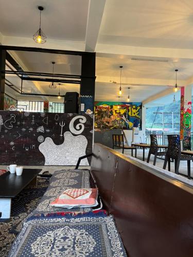 a restaurant with a bar with a table and chairs at Himtrek Stay Kasol in Kasol