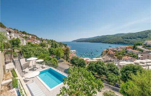 a resort with a swimming pool and a body of water at Holiday Home Plominska Ii in Rabac