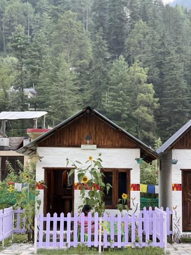 a white fence in front of a white house at Himtrek Stay Kasol in Kasol