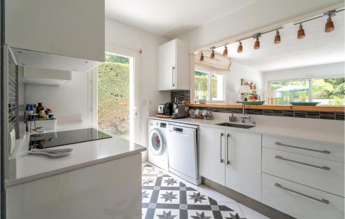 une cuisine avec des armoires blanches et une laveuse et une sécheuse dans l'établissement Beautiful Home In Lège-Cap-Ferret, à Lège-Cap-Ferret