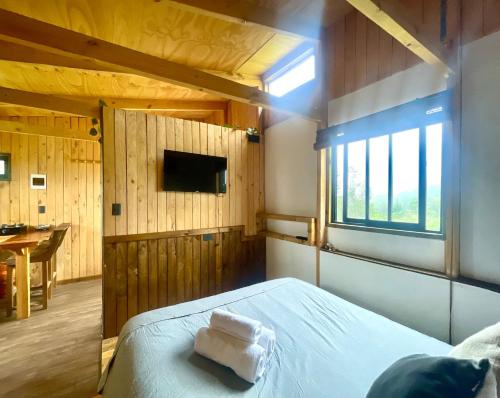 a bedroom with a bed with two towels on it at Tiny Catamarán in Cobquecura