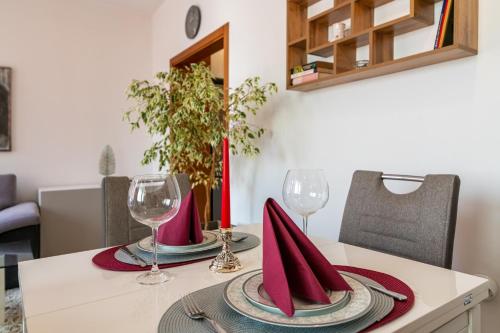 a dining room table with two wine glasses and napkins at Apartment DOLCE CASA in Varna City