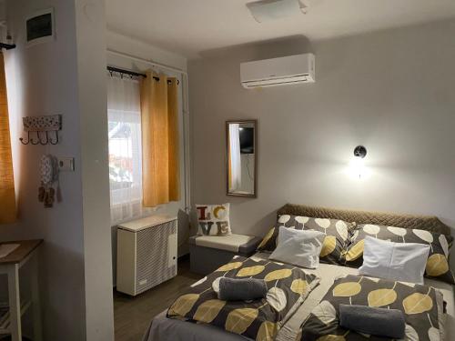 ein kleines Schlafzimmer mit einem Bett und einem Fenster in der Unterkunft Sára Vendégház in Hajdúböszörmény