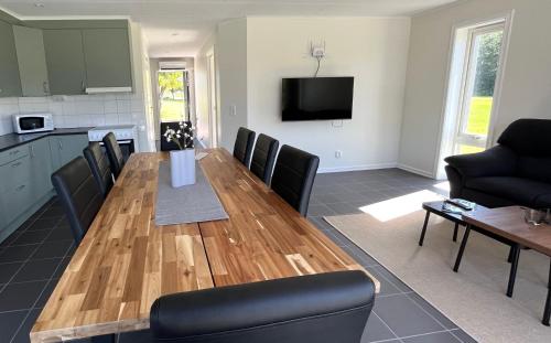 a kitchen and dining room with a wooden table and chairs at Saxnäs Ferieboende Loke in Färjestaden