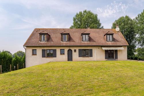 a house on top of a grassy hill at La Gravière in Fontenay-Trésigny