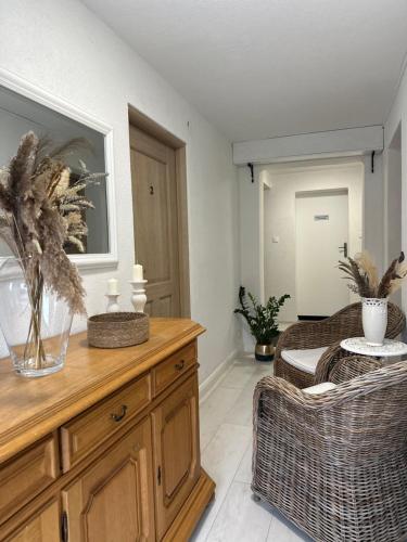 a living room with a wooden dresser and wicker chairs at APARTAMENTY LAVENDERIA z widokiem na Górę Parkową, blisko centrum in Kudowa-Zdrój