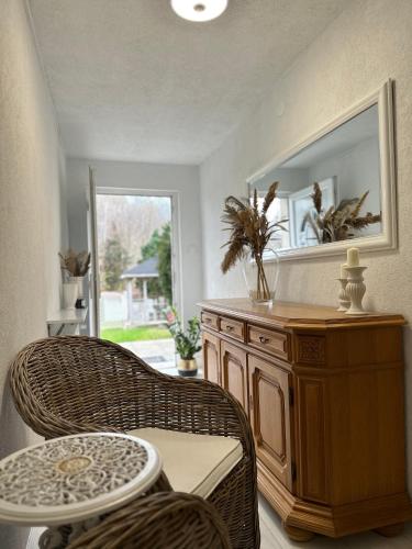 a room with a wicker chair and a table and a mirror at APARTAMENTY LAVENDERIA z widokiem na Górę Parkową, blisko centrum in Kudowa-Zdrój